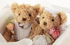 プリザーブドフラワーの花束を抱えたグレース・ベア｜結婚式にも人気のぬいぐるみ祝電