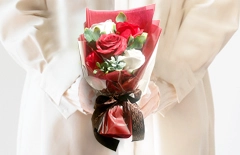 赤と白のローズソープフラワー花束を持つ女性